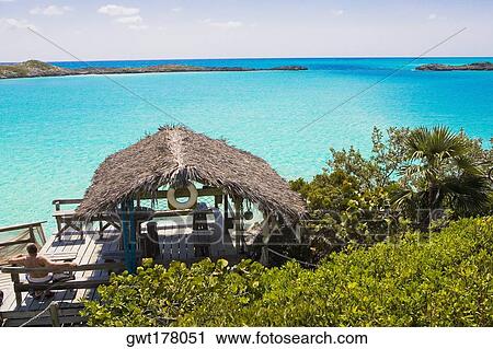 Rear view of a man sitting on a bench, Exuma, Bahamas View Large Photo Image Stock Image - Rear view of a man sitting on a bench, Exuma, Bahamas. Fotosearch