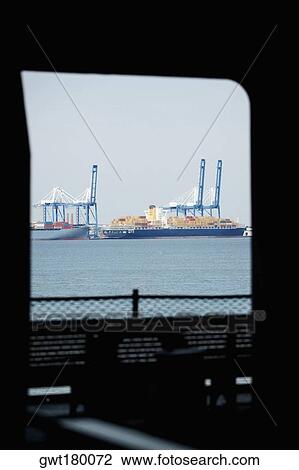 Container ships docked at a commercial dock viewed through the window of a ship, Patriot's Point, Charleston Harbor, Charleston, South Carolina, USA View Large Photo Image Stock Image - Container ships docked at a commercial dock viewed through the window of a ship, Patriot's Point, Charleston Harbor, Charleston, South Carolina, USA. Fotosearch