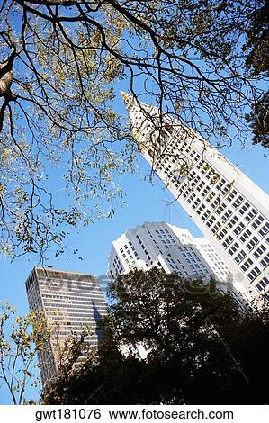 Stock Photograph - Low angle view of a clock tower near skyscrapers, New York City, New York State, USA. Fotosearch