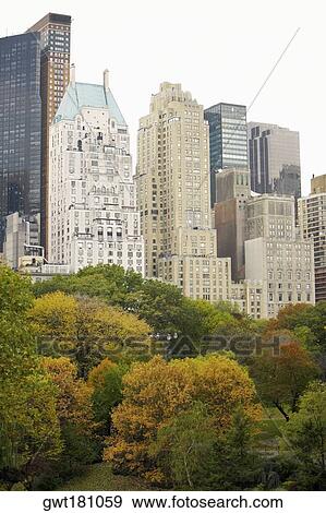 Trees in front of buildings, Central Park, Manhattan, New York City, New York State, USA View Large Photo Image Stock Photo - Trees in front of buildings, Central Park, Manhattan, New York City, New York State, USA. Fotosearch