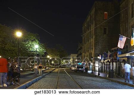 Stock Image - Group of people walking on the walkway at night, Savannah, Georgia, USA. Fotosearch