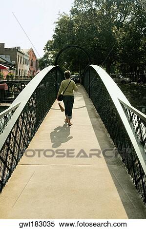 Rear view of a woman walking on a footbridge, Savannah, Georgia, USA View Large Photo Image Stock Photography - Rear view of a woman walking on a footbridge, Savannah, Georgia, USA. Fotosearch