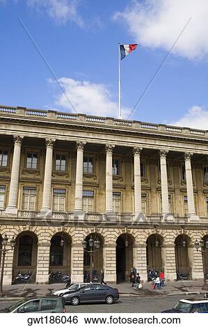Stock Photograph - Low angle view of a French flag fluttering on a hotel, Hotel Crillon, Paris, France. Fotosearch