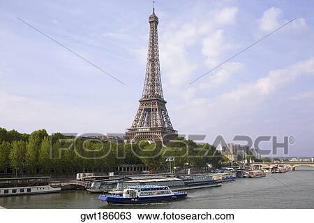 Stock Image - Tourboats moored in a river near a tower, Eiffel Tower, Seine River, Paris, France. Fotosearch