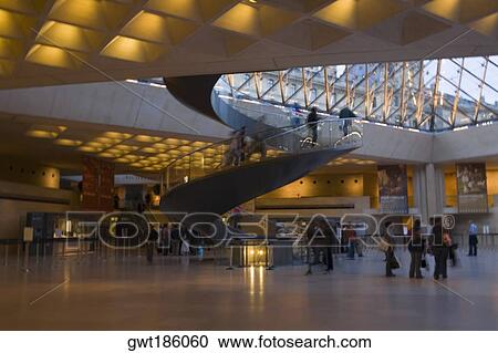 Stock Image - Tourists in an art museum, Louvre Pyramid, Musee Du Louvre, Paris, France. Fotosearch