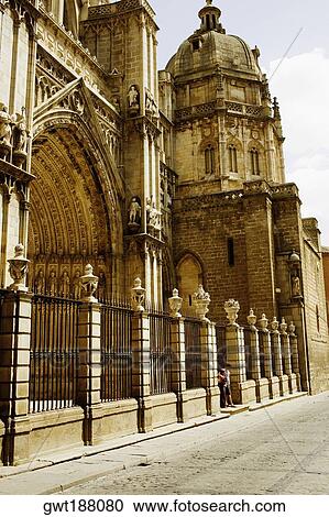 Stock Image - Tourists standing at the entrance of a cathedral, Cathedral Of Toledo, Toledo, Spain. Fotosearch