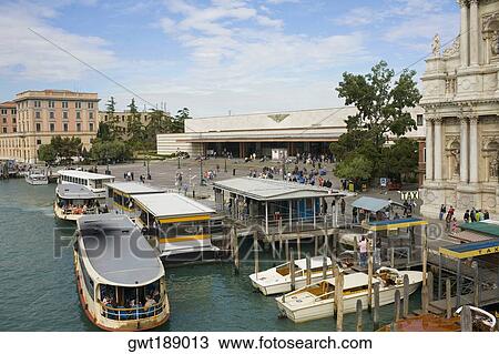 Gondolas docked in a canal in front of a railway station, Venice, Italy View Large Photo Image Stock Image - Gondolas docked in a canal in front of a railway station, Venice, Italy. Fotosearch
