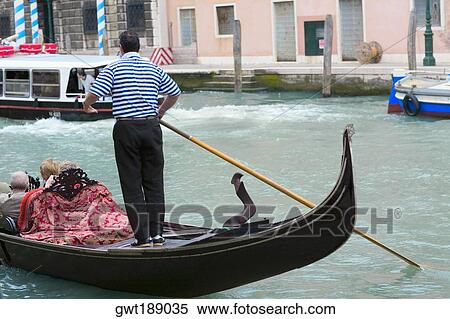 Man standing on a gondola in a canal, Grand Canal, Venice, Italy View Large Photo Image Stock Photography - Man standing on a gondola in a canal, Grand Canal, Venice, Italy. Fotosearch