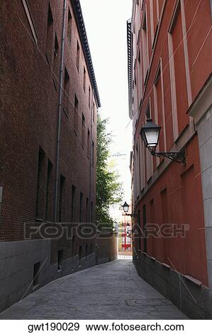 Buildings on both sides of an alley, Madrid, Spain View Large Photo Image Stock Photo - Buildings on both sides of an alley, Madrid, Spain. Fotosearch