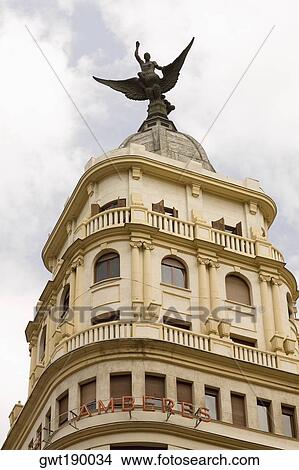 Low angle view of an angel statue on the top of a building, Madrid, Spain View Large Photo Image Picture - Low angle view of an angel statue on the top of a building, Madrid, Spain. Fotosearch