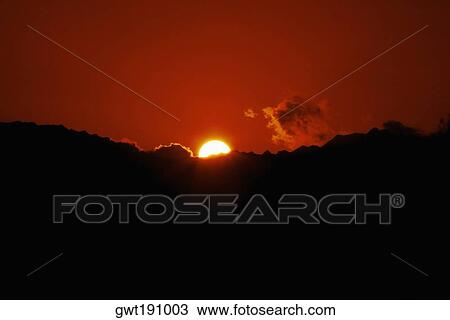 Stock Image - Sunset over a mountain, Nawiliwili Beach Park, Kauai, Hawaii Islands, USA. Fotosearch