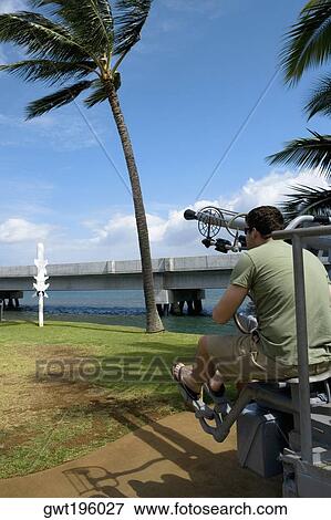Rear view of a man sitting on an artillery cannon, Pearl Harbor, Honolulu, Oahu, Hawaii Islands, USA View Large Photo Image Stock Photo - Rear view of a man sitting on an artillery cannon, Pearl Harbor, Honolulu, Oahu, Hawaii Islands, USA. Fotosearch