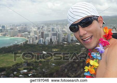 Stock Photograph - Close-up of a young man smiling, Diamond Head, Waikiki Beach, Honolulu, Oahu, Hawaii Islands, USA. Fotosearch
