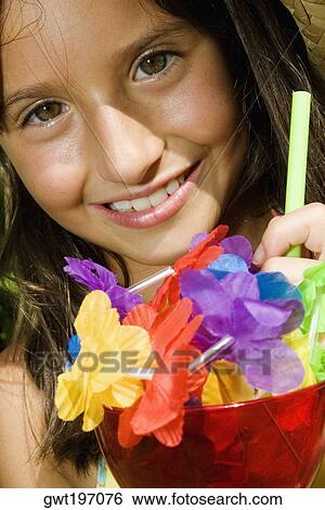Portrait of a girl holding a glass of mocktail View Large Photo Image Stock Photograph - Portrait of a girl holding a glass of mocktail. Fotosearch