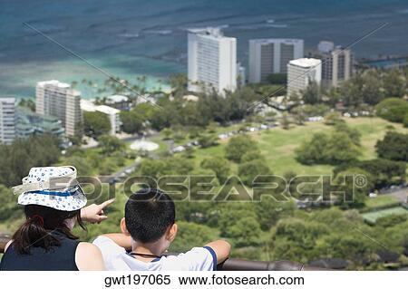 Stock Photography - Rear view of a boy and a girl looking at a city from an observation point, Diamond Head, Waikiki Beach, Honolulu, Oahu, Hawaii Islands, USA. Fotosearch