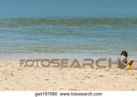 Stock Image - Rear view of a girl playing on the beach, Nawiliwili Beach Park, Kauai, Hawaii Islands, USA. Fotosearch