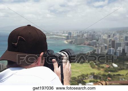 Stock Photograph - Rear view of a man taking a photograph, Diamond Head, Waikiki Beach, Honolulu, Oahu, Hawaii Islands, USA. Fotosearch