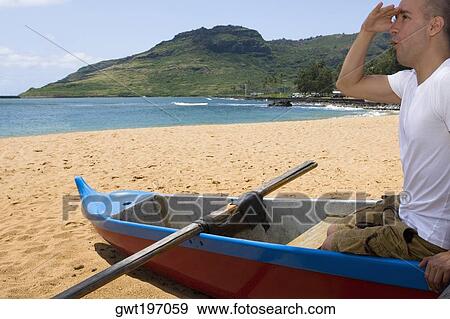 Side profile of a mid adult man sitting in a boat and shielding his eyes on the beach, Nawiliwili Beach Park, Kauai, Hawaii Islands, USA View Large Photo Image Stock Photo - Side profile of a mid adult man sitting in a boat and shielding his eyes on the beach, Nawiliwili Beach Park, Kauai, Hawaii Islands, USA. Fotosearch