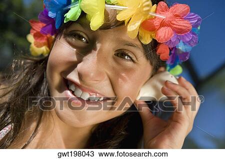 Close-up of a girl listening to a conch shell and smiling View Large Photo Image Stock Image - Close-up of a girl listening to a conch shell and smiling. Fotosearch