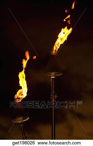 Flame burning from tiki torches View Large Photo Image Stock Photograph - Flame burning from tiki torches. Fotosearch