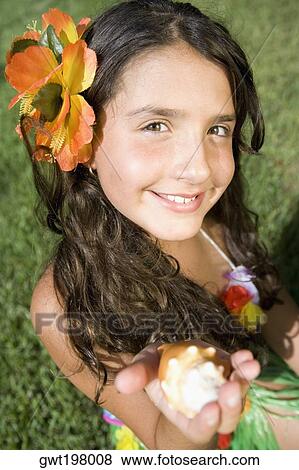 Portrait of a girl holding a conch shell and smiling View Large Photo Image Stock Photo - Portrait of a girl holding a conch shell and smiling. Fotosearch