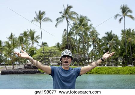 Young man standing with his arms outstretched and shouting, Captain Cook's Monument, Kealakekua Bay, Kona Coast, Big Island, Hawaii islands, USA View Large Photo Image Stock Photo - Young man standing with his arms outstretched and shouting, Captain Cook's Monument, Kealakekua Bay, Kona Coast, Big Island, Hawaii islands, USA. Fotosearch
