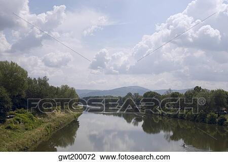 Stock Image - Reflection of trees in water, Arno River, Florence, Italy. Fotosearch