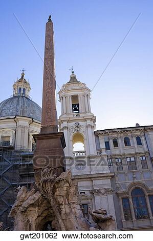 Low angle view of an obelisk in front of a church, Fountain of the Four Rivers, Piazza Navona, Rome, Italy View Large Photo Image Stock Image - Low angle view of an obelisk in front of a church, Fountain of the Four Rivers, Piazza Navona, Rome, Italy. Fotosearch