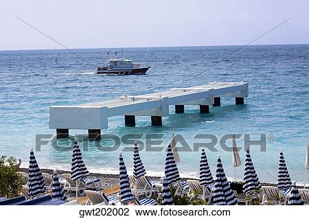 Jetty in the sea with a passenger ship in the background, Nice, France View Large Photo Image Stock Image - Jetty in the sea with a passenger ship in the background, Nice, France. Fotosearch