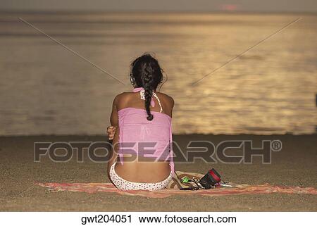 Rear view of a woman sitting on the beach, Taganga Bay, Departamento De Magdalena, Colombia View Large Photo Image Stock Image - Rear view of a woman sitting on the beach, Taganga Bay, Departamento De Magdalena, Colombia. Fotosearch