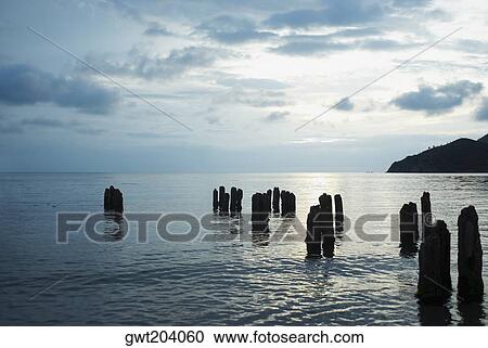 Stock Image - Wooden posts in the sea, Taganga Bay, Departamento De Magdalena, Colombia. Fotosearch