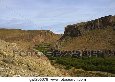 Trees surrounded by mountains, Pinturas River, Patagonia, Argentina View Large Photo Image Stock Photo - Trees surrounded by mountains, Pinturas River, Patagonia, Argentina. Fotosearch