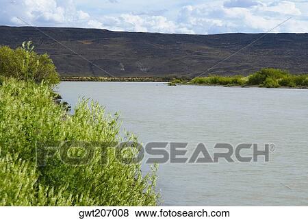 Stock Photo - Mountains at the riverside, Rio Chico, Patagonia, Argentina. Fotosearch