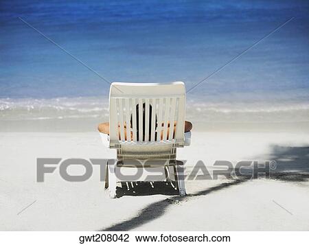 Rear view of a person lying on a lounge chair on the beach, South West Bay, Providencia, Providencia y Santa Catalina, San Andres y Providencia Department, Colombia View Large Photo Image Stock Image - Rear view of a person lying on a lounge chair on the beach, South West Bay, Providencia, Providencia y Santa Catalina, San Andres y Providencia Department, Colombia. Fotosearch
