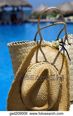 Stock Photo - Close-up of a straw hat and a straw bag at the poolside, Cancun, Mexico. Fotosearch