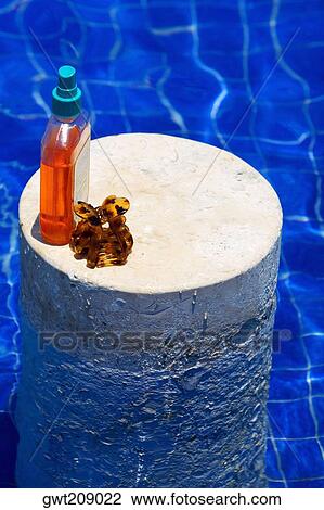 High angle view of an oil bottle and a clutcher on a column in a swimming pool, Cancun, Mexico View Large Photo Image Stock Image - High angle view of an oil bottle and a clutcher on a column in a swimming pool, Cancun, Mexico. Fotosearch