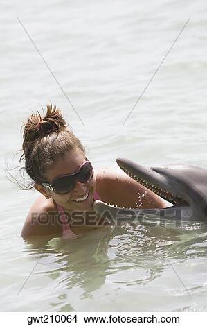 Picture - Teenage girl playing with a dolphin, Roatan, Bay Islands, Honduras. Fotosearch