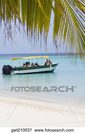 Stock Photo - Tourists traveling in a tourboat in the sea, Honduras. Fotosearch