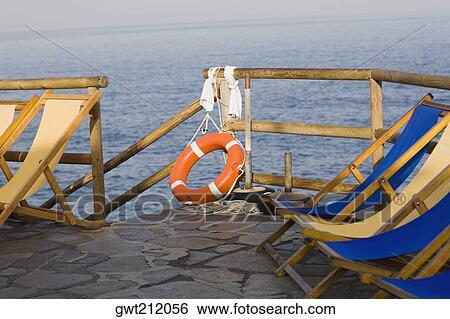 Deck chairs and a life belt on a pier, Capri, Campania, Italy View Large Photo Image Stock Photograph - Deck chairs and a life belt on a pier, Capri, Campania, Italy. Fotosearch