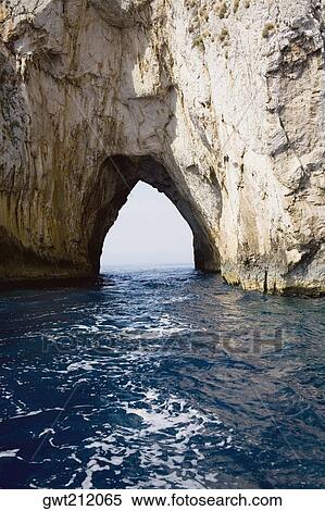 Natural arch in a rock formation, Faraglioni Rocks, Capri, Campania, Italy View Large Photo Image Stock Photography - Natural arch in a rock formation, Faraglioni Rocks, Capri, Campania, Italy. Fotosearch