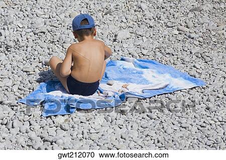 Rear view of a boy sitting on a blanket, Capri, Campania, Italy View Large Photo Image Stock Image - Rear view of a boy sitting on a blanket, Capri, Campania, Italy. Fotosearch