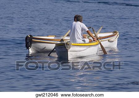 Rear view of two men sitting in boats, Capri, Campania, Italy View Large Photo Image Stock Photograph - Rear view of two men sitting in boats, Capri, Campania, Italy. Fotosearch