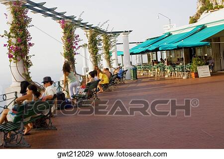 Tourists sitting on the benches, Piazza Umberto, Capri, Campania, Italy View Large Photo Image Stock Photo - Tourists sitting on the benches, Piazza Umberto, Capri, Campania, Italy. Fotosearch