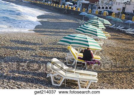 Beach umbrellas and lounge chairs on the beach, Rhodes, Dodecanese Islands, Greece View Large Photo Image Stock Photo - Beach umbrellas and lounge chairs on the beach, Rhodes, Dodecanese Islands, Greece. Fotosearch