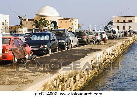 Stock Image - Cars parked at the roadside, Rhodes, Dodecanese Islands, Greece. Fotosearch