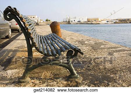 Stock Image - Empty bench at the seaside, Rhodes, Dodecanese Islands, Greece. Fotosearch