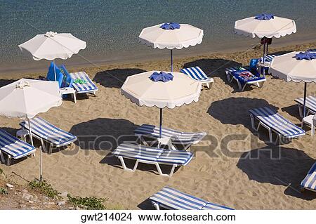 Picture - High angle view of beach umbrellas and lounge chairs on the beach, Rhodes, Dodecanese Islands, Greece. Fotosearch