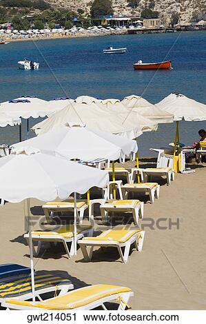 Lounge chairs and beach umbrellas on the beach, Lindos, Rhodes, Dodecanese Islands, Greece View Large Photo Image Stock Image - Lounge chairs and beach umbrellas on the beach, Lindos, Rhodes, Dodecanese Islands, Greece. Fotosearch