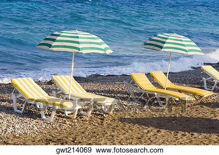 Lounge chairs and beach umbrellas on the beach, Rhodes, Dodecanese Islands, Greece View Large Photo Image Stock Photo - Lounge chairs and beach umbrellas on the beach, Rhodes, Dodecanese Islands, Greece. Fotosearch