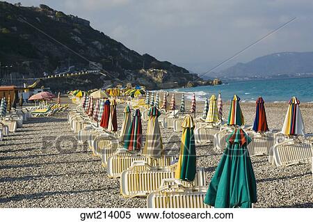 Lounge chairs and beach umbrellas on the beach, Rhodes, Dodecanese Islands, Greece View Large Photo Image Stock Photography - Lounge chairs and beach umbrellas on the beach, Rhodes, Dodecanese Islands, Greece. Fotosearch
